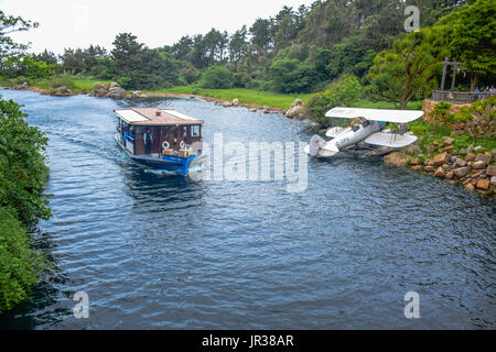 CHIBA, JAPAN: A boat full of passengers is passing through the river in the middle of the jungle in Tokyo Disneysea Stock Photo