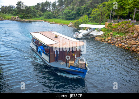 CHIBA, JAPAN: A boat full of passengers is passing through the river in the middle of the jungle in Tokyo Disneysea Stock Photo