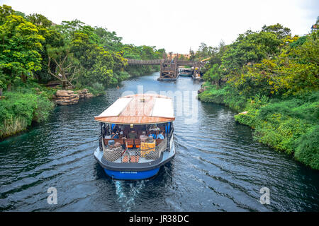 CHIBA, JAPAN: A boat full of passengers is passing through the river in the middle of the jungle in Tokyo Disneysea Stock Photo