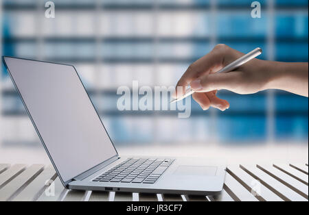 hand holding pen working on computer notebook Stock Photo