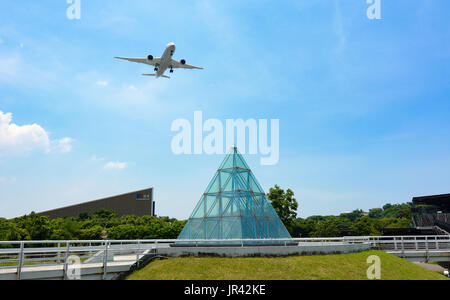 TAIPEI, TAIWAN - JULY 1, 2017 - Commercial passenger plane deploying landing gear over Taipei Expo Park to land at Songshan Airport Stock Photo