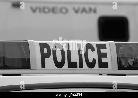 Closeup of police car sign with video unit vehicle in background. Stock Photo