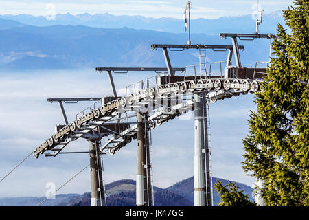 Ski lift cable booth or car, Ropeway and cableway transport sistem for skiers with fog on valley background . Stock Photo