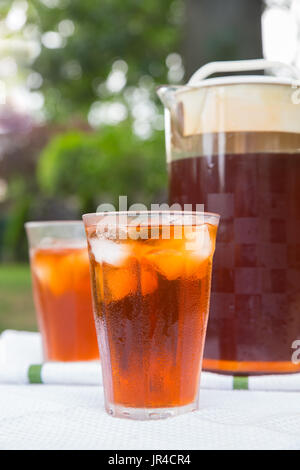 Pitcher of iced tea and a glass in outdoor backyard summer setting Stock Photo