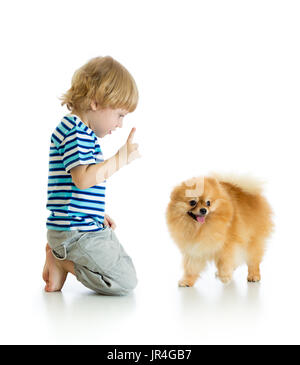 Child boy training Spitz dog. Isolated on white background. Stock Photo