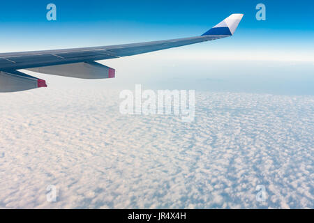 Winglet of an aircraft Airbus A330-300 of China Airlines CI-917 in flight, above stratocumulus clouds, against blue sky, fly from Taiwan to Hong Kong Stock Photo