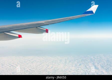 Winglet of an aircraft Airbus A330-300 of China Airlines CI-917 in flight, above stratocumulus clouds, against blue sky, fly from Taiwan to Hong Kong Stock Photo