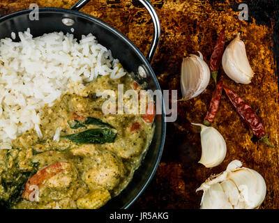 Thai Green Chicken Curry With Rice Against a Distressed Used Oven or Baking Tray Stock Photo