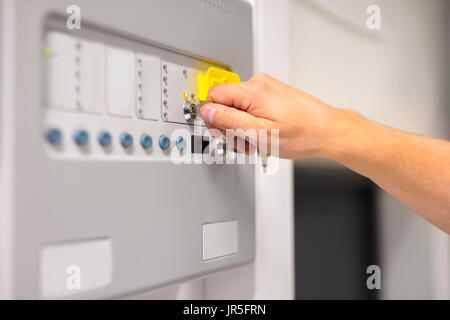 IT Engineer Using Key To Open Fire Panel In Datacenter Stock Photo