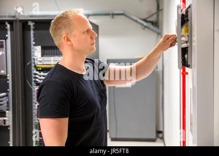 Confident Male Technician Opening Fire Panel In Datacenter Stock Photo