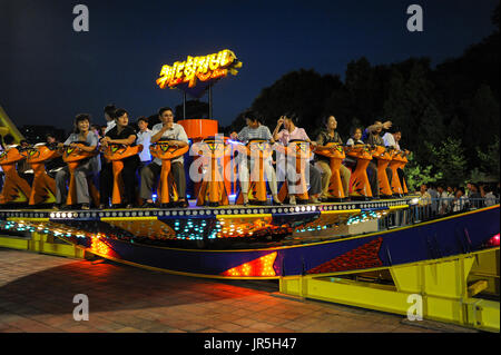 10.08.2012, Pyongyang, North Korea, Asia - North Koreans enjoy a fun ride at the Kaeson Youth Park in Pyongyang. Stock Photo