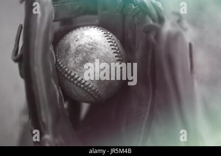 Old rough baseball caught in glove.  Ball player vintage style monochrome image.  Great for print decor or graphic background. Stock Photo