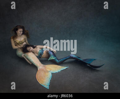 Two young mermaids relaxing together Stock Photo