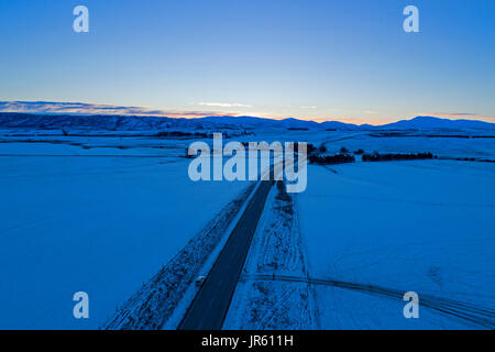 State Highway 85 in winter at sunset, near Oturehua, Maniototo, Central Otago, South Island, New Zealand - drone aerial Stock Photo
