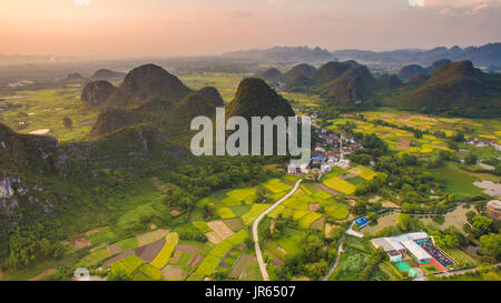 Aerial view of a village surrounded by Padi fields and hills in Guanxi, China Stock Photo