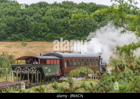 retro vintage steam train pulling into the old railway station in the countryside Stock Photo