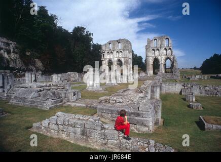 Exploring the ruins of Roche Abbey, South Yorkshire, England - a moment to rest and look for a five-year-old boy. Stock Photo