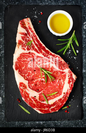 Raw Dry Aged Steak with rosemary and olive oil Stock Photo