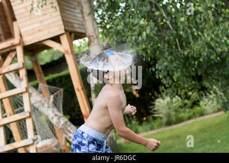 Water bomb landing on a boy's face Stock Photo