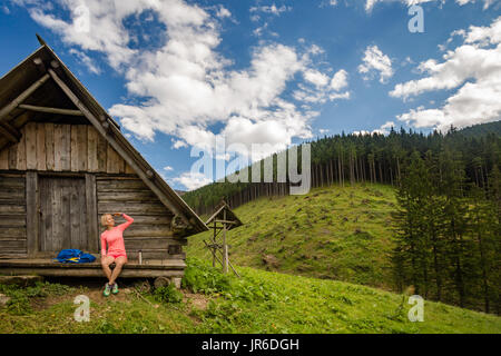 Young woman hiker camping and looking at beautiful view in Tatra mountains on hiking trip. Inspirational landscape in Poland. Active girl resting outd Stock Photo
