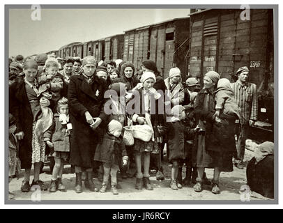 Auschwitz-Birkenau Jewish women and children some wearing Nazi designated yellow stars arrive by basic rail trucks to Auschwitz-Birkenau, a WW2 German Nazi Concentration camp. Jewish children were the largest group deported to the camp. They were sent along with adults, beginning in early 1942, as part of the “final solution of the Jewish question”—the total destruction of the Jewish population of Europe...Auschwitz concentration camp was a network of German Nazi concentration and extermination camps operated by the Third Reich in Polish areas annexed by Nazi Germany during World War II. Stock Photo