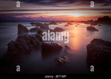 Bude, Cornwall, United Kingdom at sunset, beautiful seascape, sea against rocks with a slow shutter speed Stock Photo