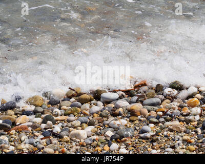 Wet pebbles on a sea shore Stock Photo