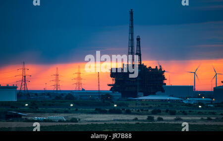 Seaton Carew, north east England, UK, 4th August, 2017. UK Weather: A fiery sky at sunrise behind the 130 metre tall, 24,000  tonne Brent Delta Topside oil platform being recycled at Able  UK`s Seaton port site. Prior to the rig arriving in May 2017,  £28 million was spent building a new quay to facilitate the largest-ever oil rig demolition project. Credit: ALAN DAWSON/Alamy Live News Stock Photo