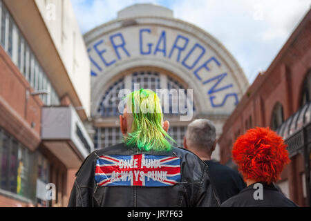 'Once Punk Always Punk' Couple with dyed hair in Blackpool, Lancashire, UK. August 2017. Rebellion Festival world's largest punk festival begins as thousands of punks arrive in Blackpool for the international punk festival. At the beginning of August, Blackpool’s Winter Gardens plays host to a massive lineup of punk bands for the 21st edition of Rebellion Festival at the Winter Gardens. Stock Photo