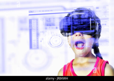 Young child wearing a virtual reality VR headset enjoys various high technology HUD digital effect displays Stock Photo