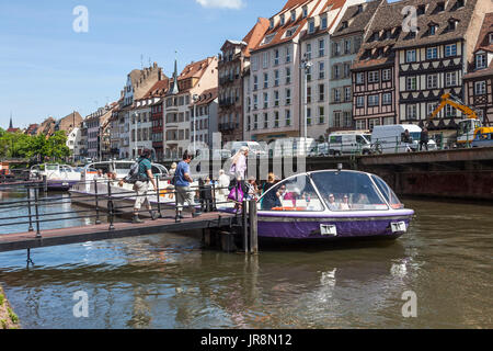 Tourists boarding a Batorama sightseeing boat / Bateau-promenade on the River Ill in central Strasbourg, Alsace, France. Some typical architecture of  Stock Photo