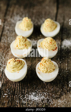 Homemade deviled eggs with smoked paprika on wooden board Stock Photo