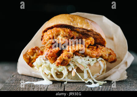 Fried crispy chicken sandwich with coleslaw on dark background horizontal Stock Photo