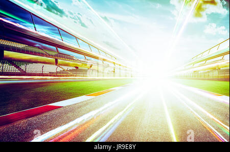 View of the infinity empty asphalt international race track  with light trail effect . evening scene . Stock Photo