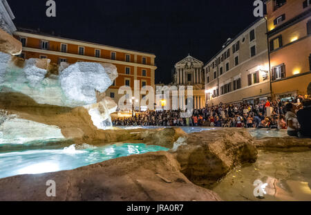 The crowds of people in the evening at the Trevi Fountain with the church in the background in Rome Italy Stock Photo