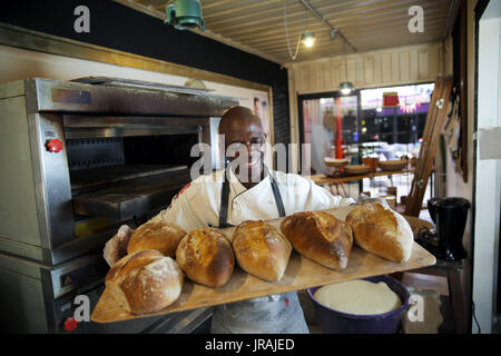 Baker holding tray of fresh bread Stock Photo