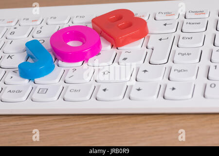 Job plastic lettering arranged on computer keyboard in close-up Stock Photo