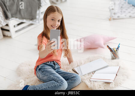 Cute schoolgirl in casual taking selfies Stock Photo