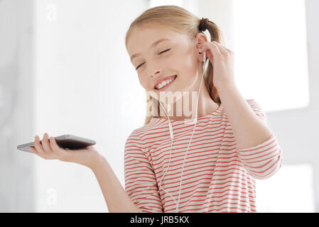 Cute little girl listening to her favorite music album Stock Photo