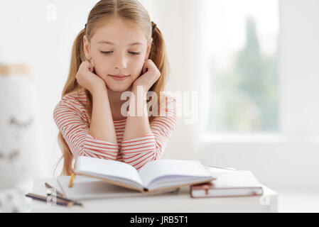 Smart female pupil doing homework Stock Photo