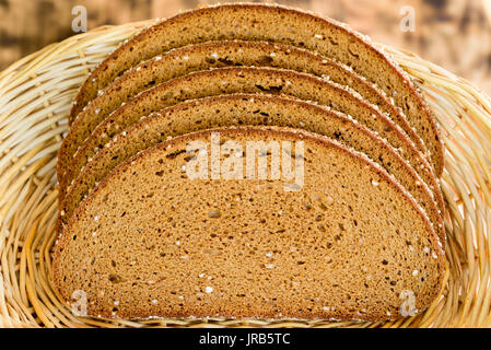 Sliced whole grain bread in a wicker basket. Stock Photo