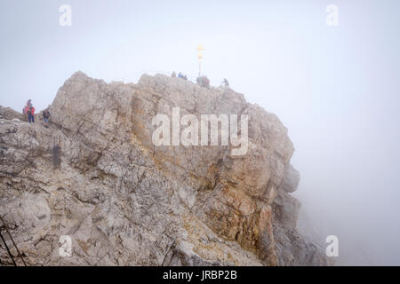 people on the Zugspitze summit by the summit cross, Bavaria, Germany Stock Photo