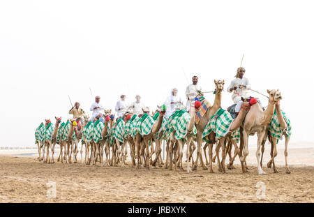 Rub al Khali Desert, Abu Dhabi, United Arab Emirates, July 22nd, 2017: men training camels at a camel track in a desert Stock Photo