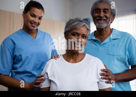 Portrait of smiling seniors with nurse in retirement home Stock Photo