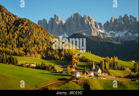 St. Magdalena with its characteristic church in front of the Geisler Dolomites mountain peaks in the Villnoess valley in Italy in an autumn landscape. Stock Photo