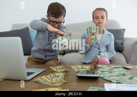 Business people counting currency while sitting on sofa at office Stock Photo