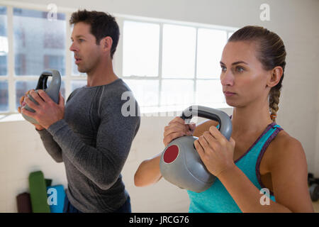 Dedicated athletes exercising with kettlebells in gym Stock Photo