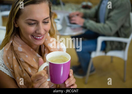 High angle close up of young woman holding coffee cup in gym Stock Photo