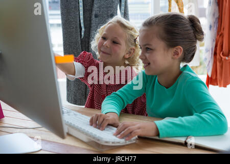 Female designers discussing over computer in creative office Stock Photo