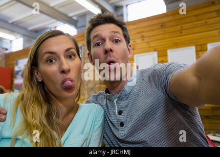 Portrait of playful couple making faces in cafe Stock Photo